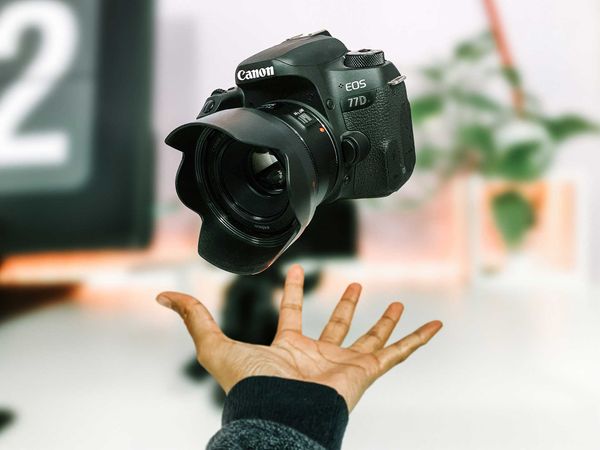 χέρι με φωτογραφική κάμερα για επαγγελματική φωτογράφιση προϊόντων